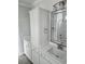 Bathroom with double vanities, framed mirrors, and storage cabinet with stone countertops at 4823 Riverside Dr., North Myrtle Beach, SC 29582