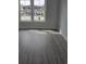 Bedroom with vinyl flooring and a view of the neighborhood through two windows at 4823 Riverside Dr., North Myrtle Beach, SC 29582
