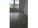 A light-filled bedroom with wood-look flooring and a large window showcases the outside view at 4823 Riverside Dr., North Myrtle Beach, SC 29582