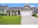 Charming single-story home with a well-manicured lawn, inviting front porch, and attached two-car garage at 505 Joy Way Ct., Longs, SC 29568