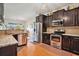 A kitchen featuring stainless appliances, dark cabinets, and granite countertops, open to a dining area at 505 Joy Way Ct., Longs, SC 29568
