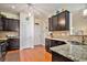 Well-equipped kitchen with granite countertops, dark cabinetry, and stainless steel sink at 505 Joy Way Ct., Longs, SC 29568