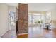 Cozy living room featuring hardwood floors, brick column, and bright natural light at 5612 N Kings Hwy., Myrtle Beach, SC 29577