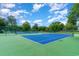 Well-maintained tennis court surrounded by lush greenery and a blue sky at 5905 S Kings Hwy. # 344B, Myrtle Beach, SC 29575