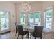 A sunlit breakfast nook with an elegant chandelier and a view of the landscaped backyard and pool at 616 Edgecreek Dr., Myrtle Beach, SC 29579