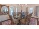 Sophisticated dining room with a glass-top table, seating for eight, elegant chandelier, and backyard view at 616 Edgecreek Dr., Myrtle Beach, SC 29579