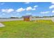 Spacious backyard featuring a shed, pergola, and lush green grass, perfect for outdoor activities at 732 American Beech St., Loris, SC 29569