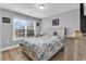 Comfortable bedroom with a blue and white comforter, wood floors, and a large window overlooking the outdoors at 732 American Beech St., Loris, SC 29569