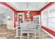 Elegant dining area with tray ceiling, bright red walls, and modern white furniture at 732 American Beech St., Loris, SC 29569