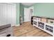 Well-organized living room with hardwood floors, a white shelving unit, and a cozy gray sofa at 732 American Beech St., Loris, SC 29569