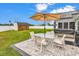 Cozy patio featuring an umbrella, dining table, chairs, hot tub, and a shed in the landscaped backyard at 732 American Beech St., Loris, SC 29569