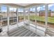 Bright sunroom with walls of windows offering serene views of the backyard and patio at 732 American Beech St., Loris, SC 29569