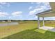 This backyard view features a well maintained lawn, a pond, and the home's covered patio at 7382 Meadow Walk Loop, Loris, SC 29569