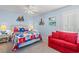 Coastal-themed bedroom with nautical quilt, matching side tables, and a vibrant red sofa at 7403 N Ocean Blvd. # C, Myrtle Beach, SC 29572