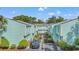 Exterior view of a row of light blue townhomes with manicured landscaping and ample parking at 7403 N Ocean Blvd. # C, Myrtle Beach, SC 29572