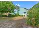 Charming exterior view of a light blue townhome with a well-maintained lawn and lush landscaping at 7403 N Ocean Blvd. # C, Myrtle Beach, SC 29572