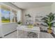 Bright home office featuring a large window, white desk, stylish shelves, and decorative plants at 7431 Meadow Walk Loop, Loris, SC 29569