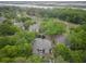 Aerial view of townhomes surrounded by lush trees, a pond, and waterfront area in the distance at 802 Colony Pl. # 2E, Calabash, NC 28468