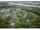 Scenic aerial view featuring a pool, tennis court and multiple buildings with lush landscaping at 802 Colony Pl. # 2E, Calabash, NC 28468