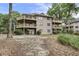 Three-story building with wooden balconies and landscaped grounds featuring mature trees at 802 Colony Pl. # 2E, Calabash, NC 28468