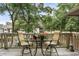 Relaxing deck area with chairs, table, flowers, and pond views surrounded by trees at 802 Colony Pl. # 2E, Calabash, NC 28468