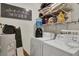 Bright laundry room featuring a washer, dryer, and shelving at 802 Colony Pl. # 2E, Calabash, NC 28468