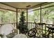 Screened-in porch features forest views, white wicker furniture, and bicycle parking at 802 Colony Pl. # 2E, Calabash, NC 28468