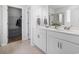 Modern bathroom with dual sinks, white cabinetry, a walk-in closet, and a tiled floor at 863 Agostino Dr., Myrtle Beach, SC 29579