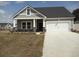 Charming single-story home with stone accents, gray siding, an attached two-car garage, and well-manicured lawn at 8715 Baton Rouge Ave Nw, Calabash, NC 28467