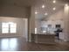 Open-concept living room and kitchen featuring hardwood floors, a modern chandelier, and a breakfast bar at 8715 Baton Rouge Ave Nw, Calabash, NC 28467