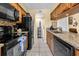 Functional kitchen featuring black appliances, granite countertops, and warm wood cabinetry at 9661 Shore Dr. # A1, Myrtle Beach, SC 29572