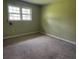 Simple bedroom with green walls, carpet flooring, and natural light from the window at 1002 S Beech Ave., Andrews, SC 29510