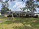 Charming single-story brick home with a spacious front lawn and mature trees under a blue sky at 1002 S Beech Ave., Andrews, SC 29510