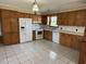 Traditional kitchen featuring wood cabinets, white appliances, and a tile floor at 1002 S Beech Ave., Andrews, SC 29510