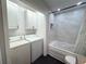 Well-lit bathroom with jacuzzi tub and shower with marble surround, black mosaic tile, and laundry equipment at 1014 Bay Dr., Surfside Beach, SC 29575