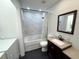 Bathroom with granite vanity, jacuzzi tub with marble surround, black mosaic tile, and laundry equipment at 1014 Bay Dr., Surfside Beach, SC 29575