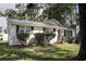 Charming white brick home with black shutters, a red front door, new landscaping, and a well manicured front yard at 1014 Bay Dr., Surfside Beach, SC 29575
