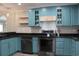Stylish kitchen featuring stainless steel appliances, granite countertops, and custom blue cabinets at 1014 Bay Dr., Surfside Beach, SC 29575