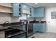 Renovated kitchen featuring blue cabinets, granite counters, stainless steel appliances, and open shelving at 1014 Bay Dr., Surfside Beach, SC 29575