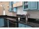 This kitchen features stainless steel appliances, granite countertops, and custom blue cabinets at 1014 Bay Dr., Surfside Beach, SC 29575