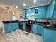 Updated kitchen with vibrant blue cabinetry, stainless steel appliances, granite countertops, and trendy backsplash at 1014 Bay Dr., Surfside Beach, SC 29575