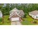 Aerial view of a charming two-story home with a two-car garage, surrounded by lush greenery and well-manicured lawns at 1033 Mccall Loop, Conway, SC 29526