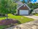 A well-manicured front yard with lush green grass and decorative landscaping surrounding a charming two-story home at 1033 Mccall Loop, Conway, SC 29526