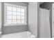 Cozy bathroom featuring a bright window over the soaking tub with a white shower curtain at 104 Clovis Circle, Myrtle Beach, SC 29579