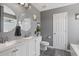 Bathroom features white dual vanities and round mirrors, accented by gray walls and tile floors at 104 Clovis Circle, Myrtle Beach, SC 29579