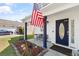 Inviting front porch with seating, garden beds, and a charming door that adds a welcoming touch to the home at 104 Clovis Circle, Myrtle Beach, SC 29579