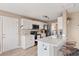 Well-lit kitchen boasts white cabinetry, stainless steel appliances, and a convenient island with barstool seating at 104 Clovis Circle, Myrtle Beach, SC 29579