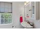 Charming bathroom featuring a pedestal sink, mirrored cabinet, and decorative window at 1140 Waterway Ln., Myrtle Beach, SC 29572