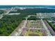 Aerial view of homes, ponds and surrounding wooded area, roads, and commercial district at 115 Machrie Loop # D, Myrtle Beach, SC 29588