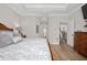 Comfortable bedroom with wood flooring, tray ceilings, and an ensuite bathroom entrance at 115 Machrie Loop # D, Myrtle Beach, SC 29588